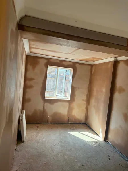 Freshly plastered room inside a new extension with a white window fitted