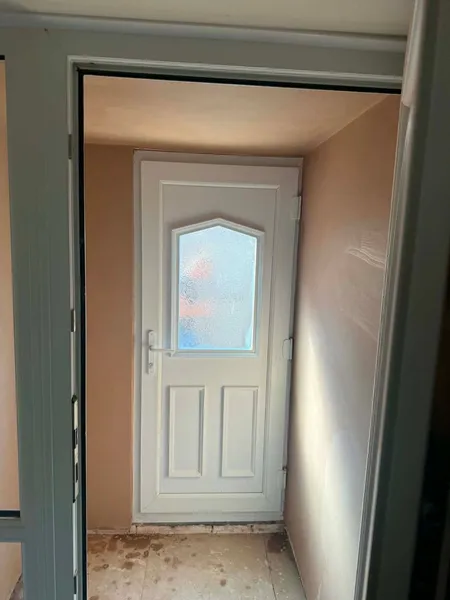 Plastered doorway inside a rear extension with a new white back door fitted