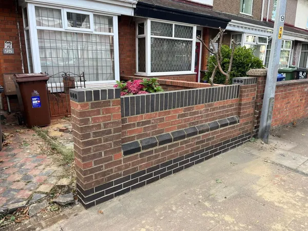 Red brick front garden wall with charcoal brick bands and coping after completion