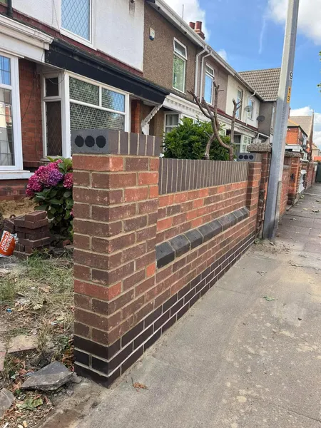 Front garden brick wall with charcoal coping viewed along the pavement after completion
