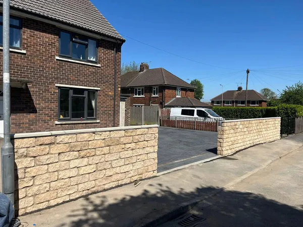 Buff stone effect front garden walls either side of a drive after completion