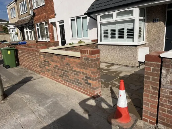 Red brick front garden wall with stone capped pillars after completion
