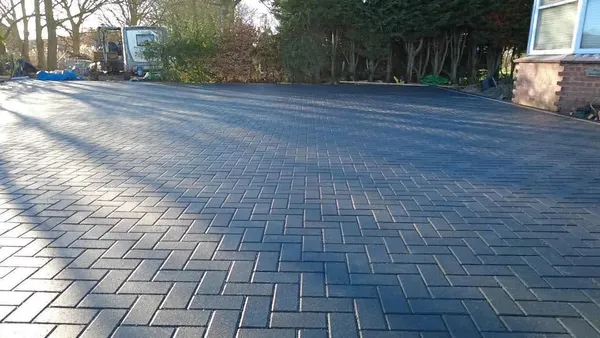 Large charcoal block paving area in front of a house after completion