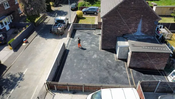 Aerial view of a large charcoal block paved area beside a house