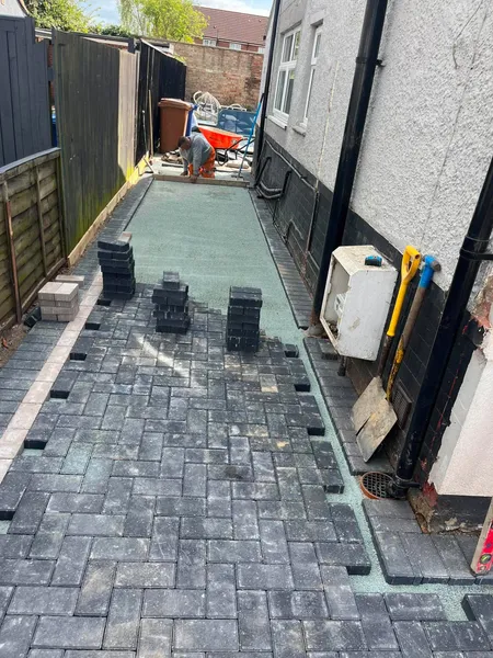Charcoal block paving side return path being laid during installation