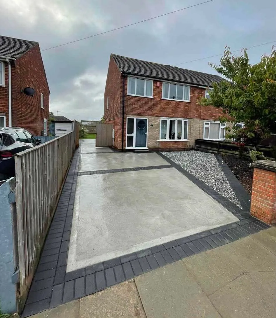 Ground level concrete drive with charcoal block edging after completion