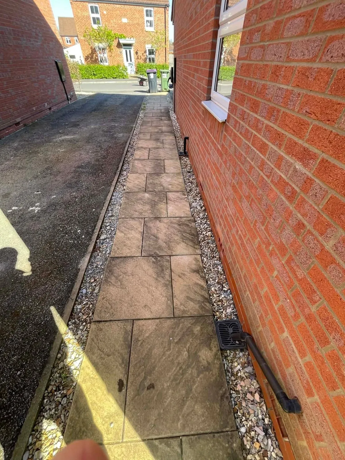 Old buff slab side path with loose gravel edges before replacement