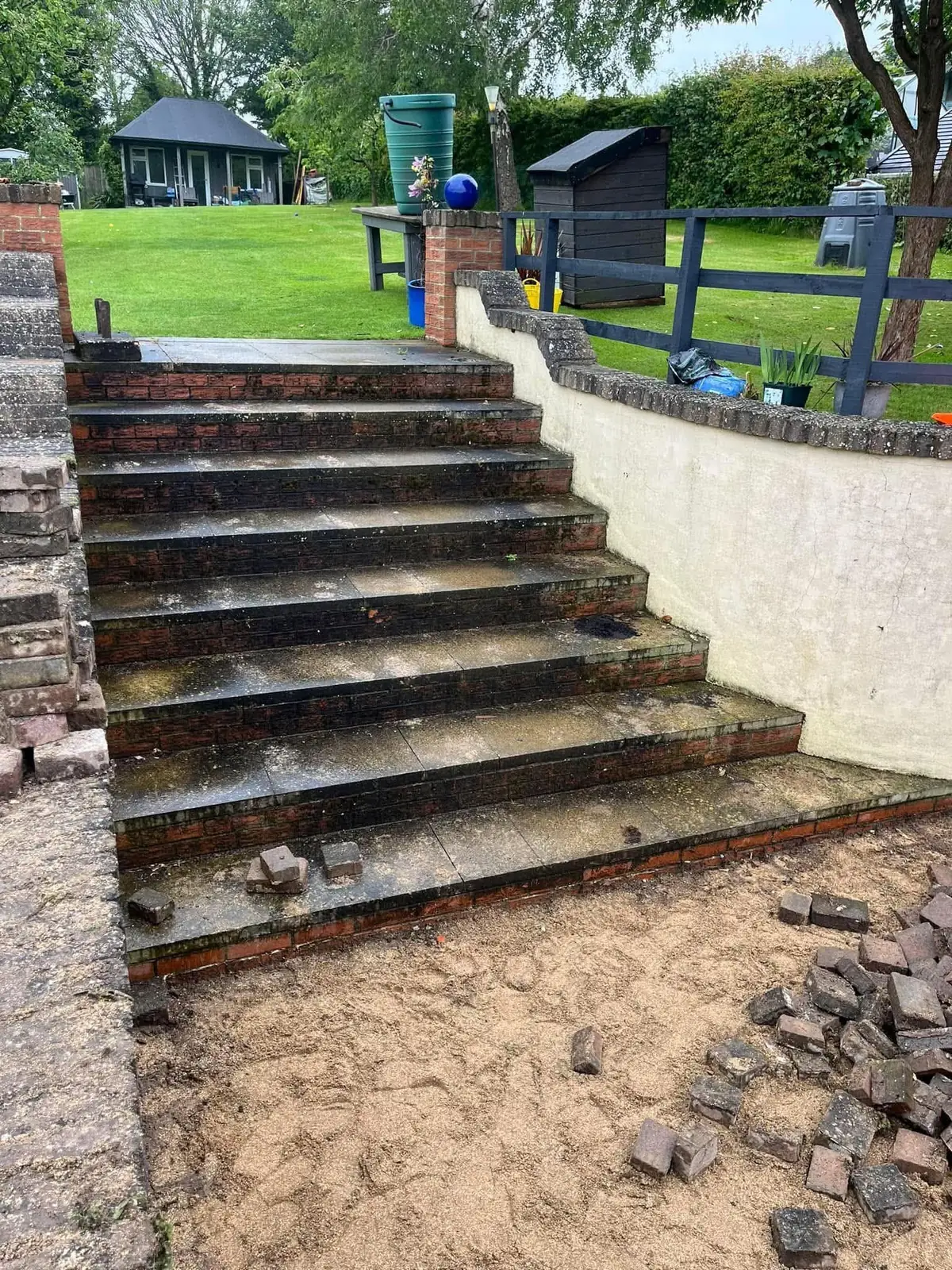 Worn brick garden steps before replacement with grey porcelain steps
