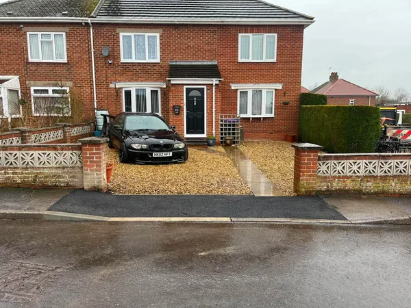 New dropped kerb and footpath crossing in front of a gravel driveway