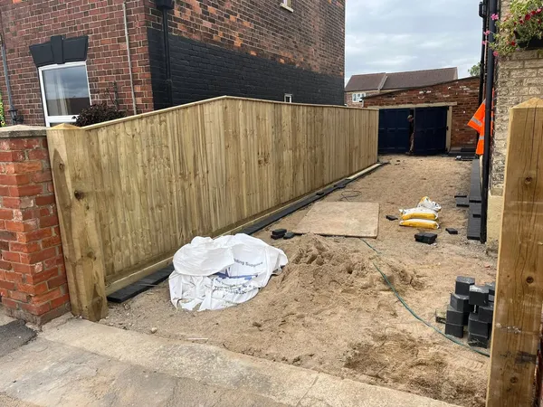 Wooden featheredge fence and gate along a garden boundary after completion