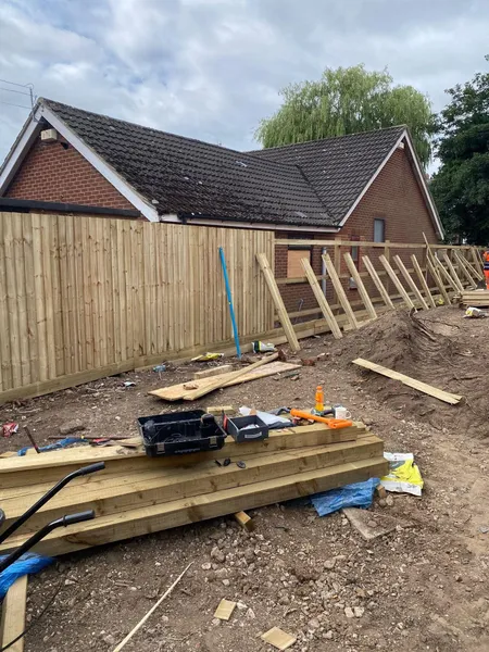 Boarded timber fence run with tools on a new build site during work