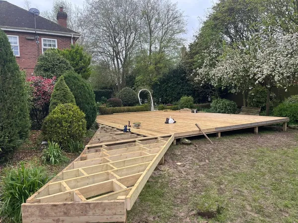 Timber decking joist frame mid build in a rear garden during construction
