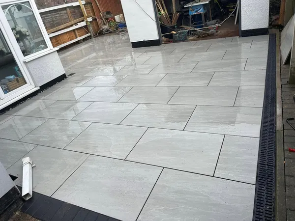 Light grey porcelain patio with channel drain installed after completion